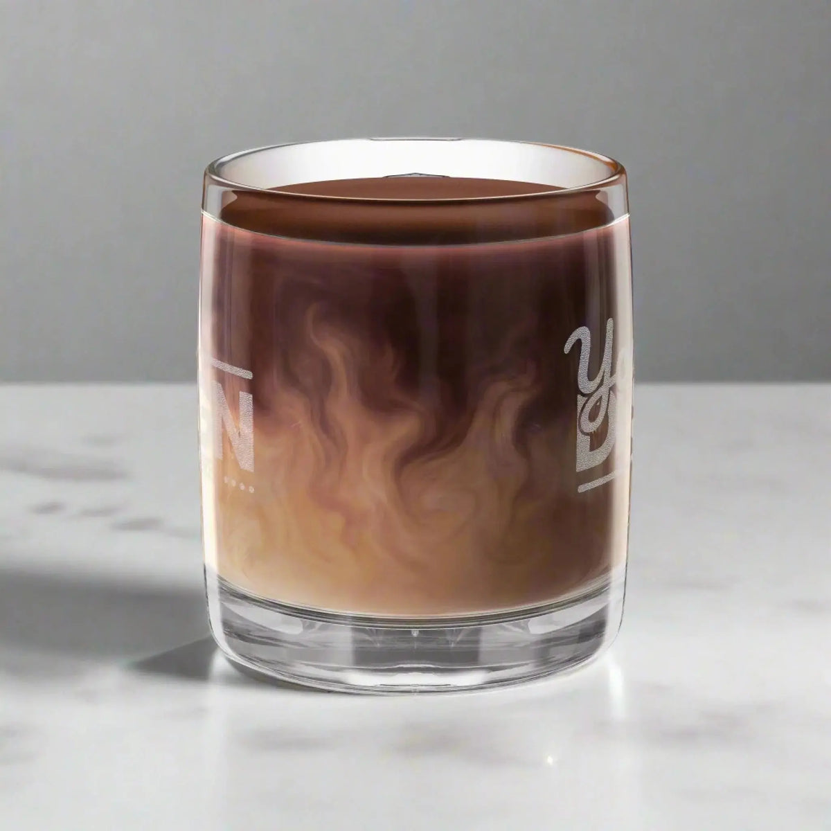 Glass_with_a_layered_drink_likely_coffee_and_cream_on_a_white_background