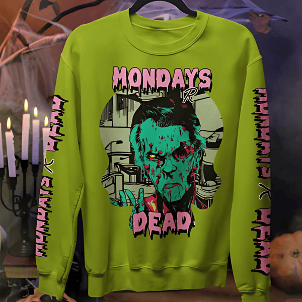 Green sweatshirt with graphic design and text on a hanger against a Halloween-themed background.