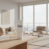 White tumbler with 'Your Design Here' text on a wooden table in a modern living room.