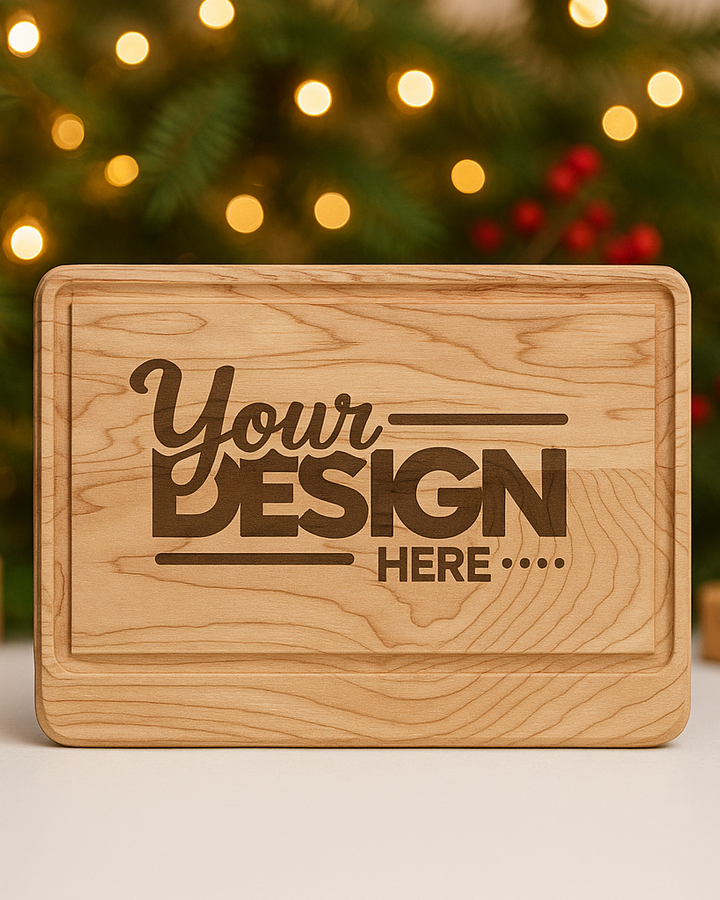 Wooden cutting board with 'Your Design Here' text in front of a Christmas tree.
